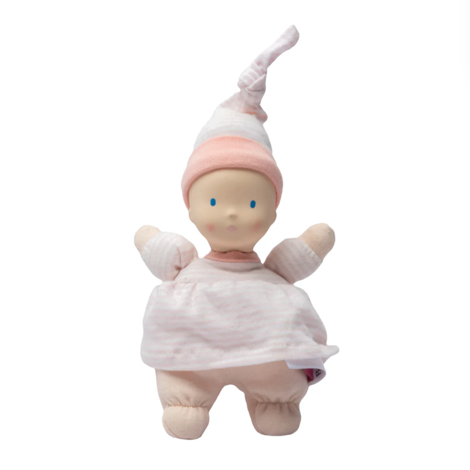 Stuffed baby doll with a pink hat and light skin tone on a white background