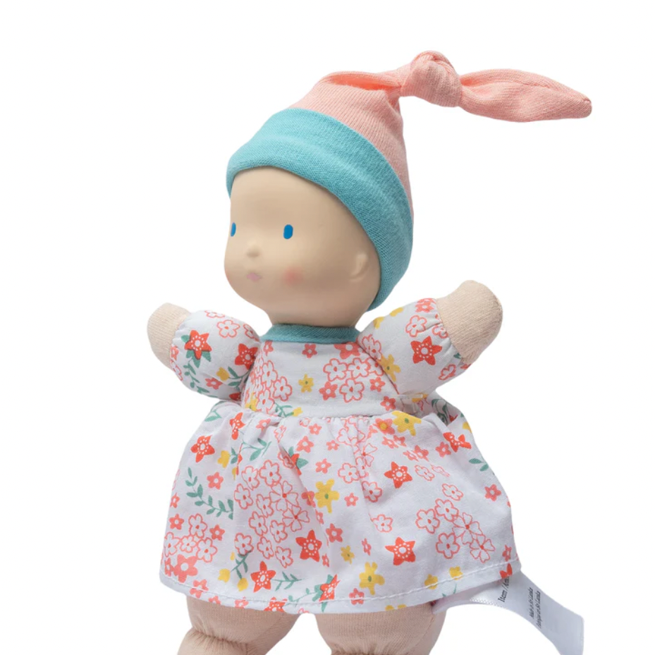 Stuffed toy with floral dress and blue hat on a white background