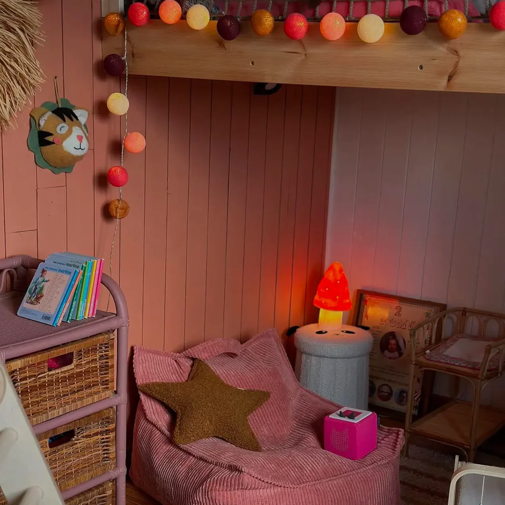 Children's room with pink bean bag chair, bookshelf, and toys.
