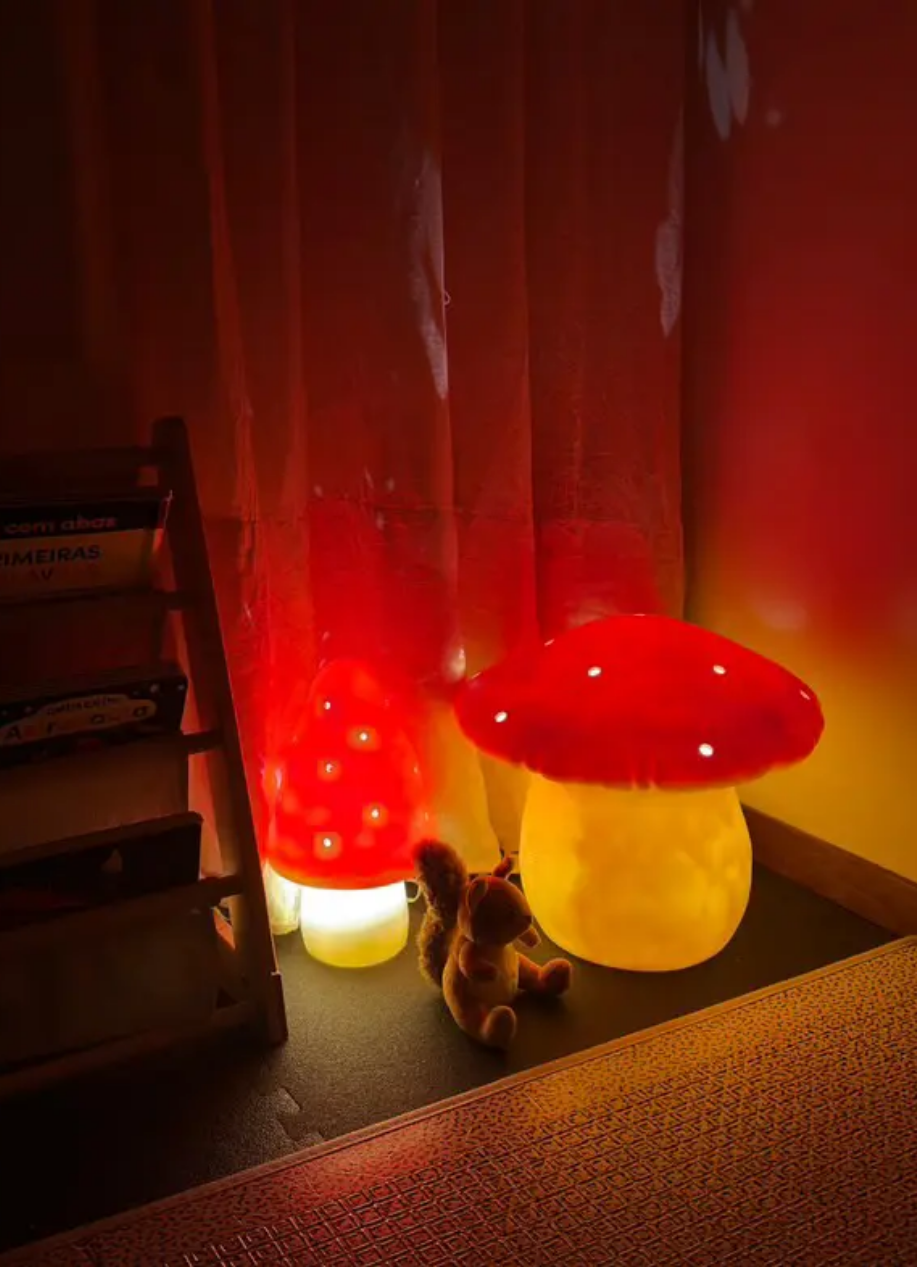 Two mushroom-shaped lamps with red caps and yellow bases on a dark floor.