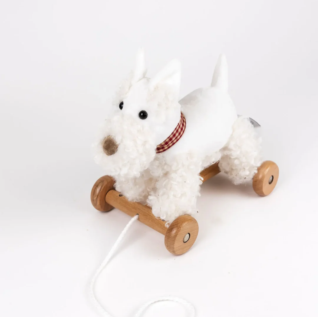 White plush dog toy with wooden wheels on a white background