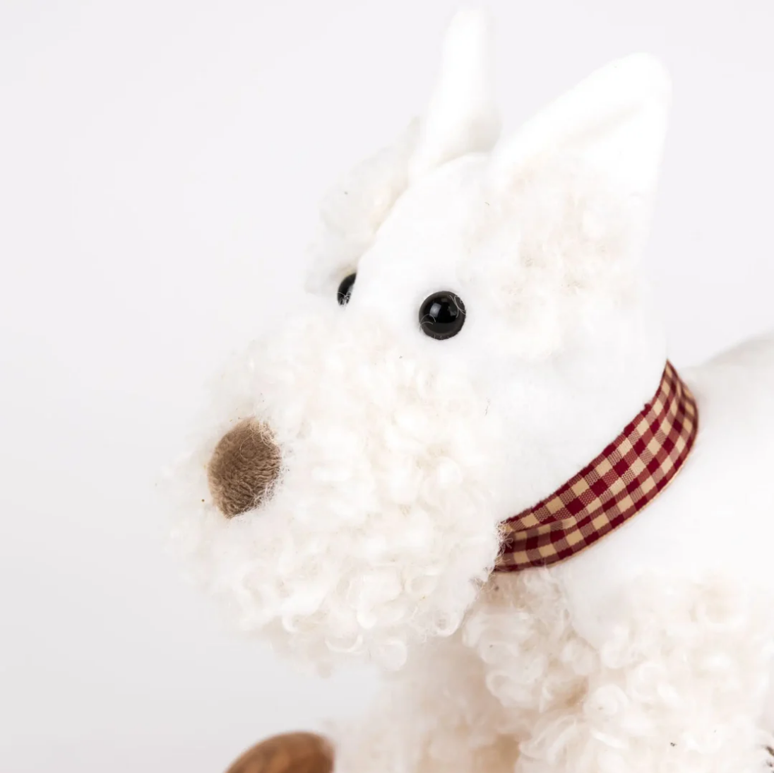 White plush dog toy with a checkered collar on a white background