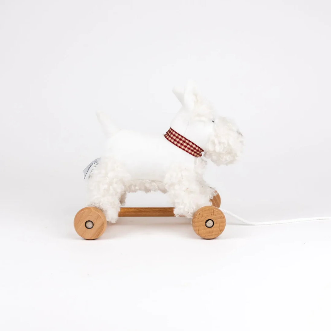 White plush toy with wooden wheels on a white background