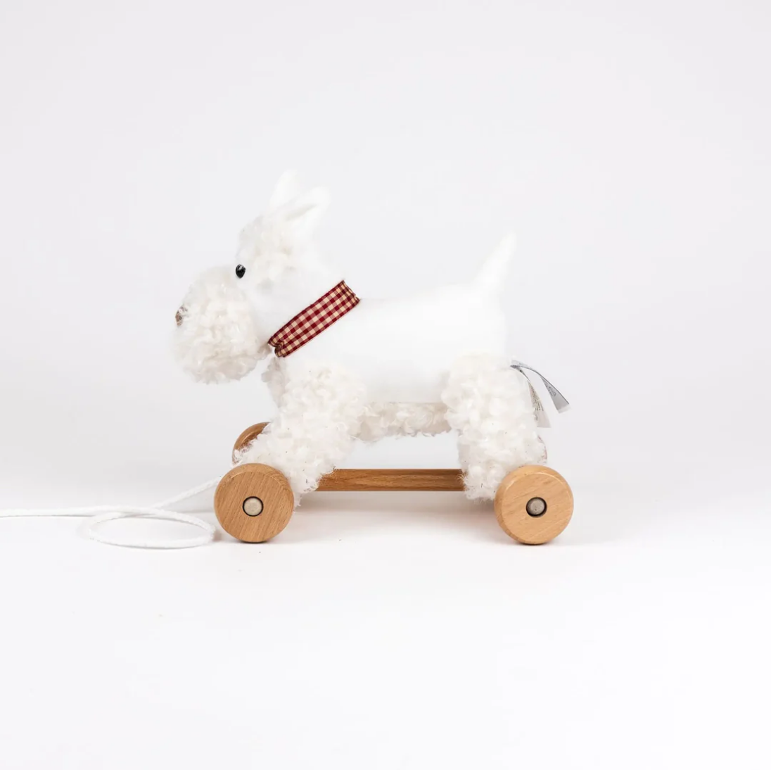 White plush toy horse with wooden wheels on a white background