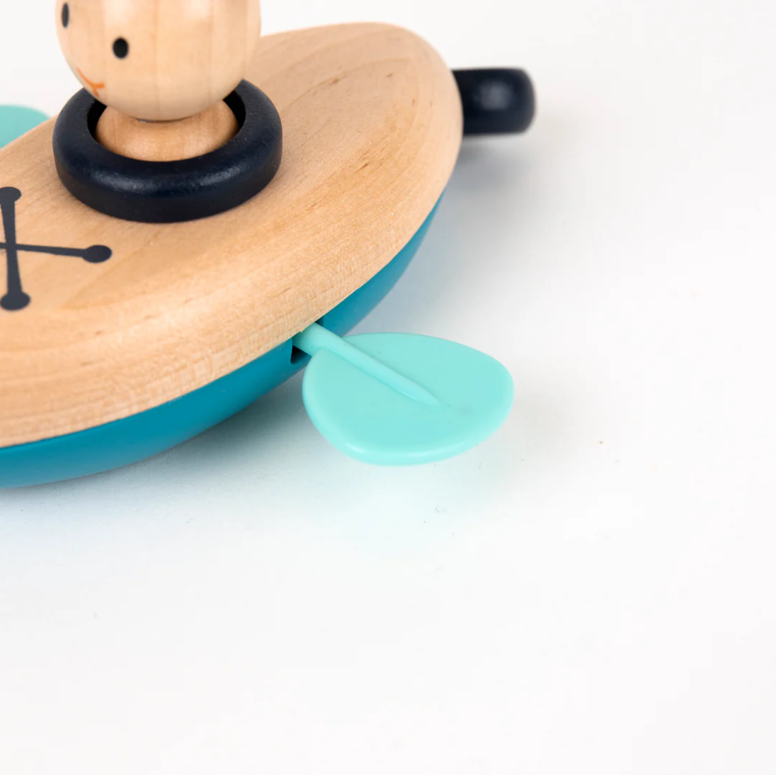 Wooden toy with a blue base and a small figure on top, on a white background