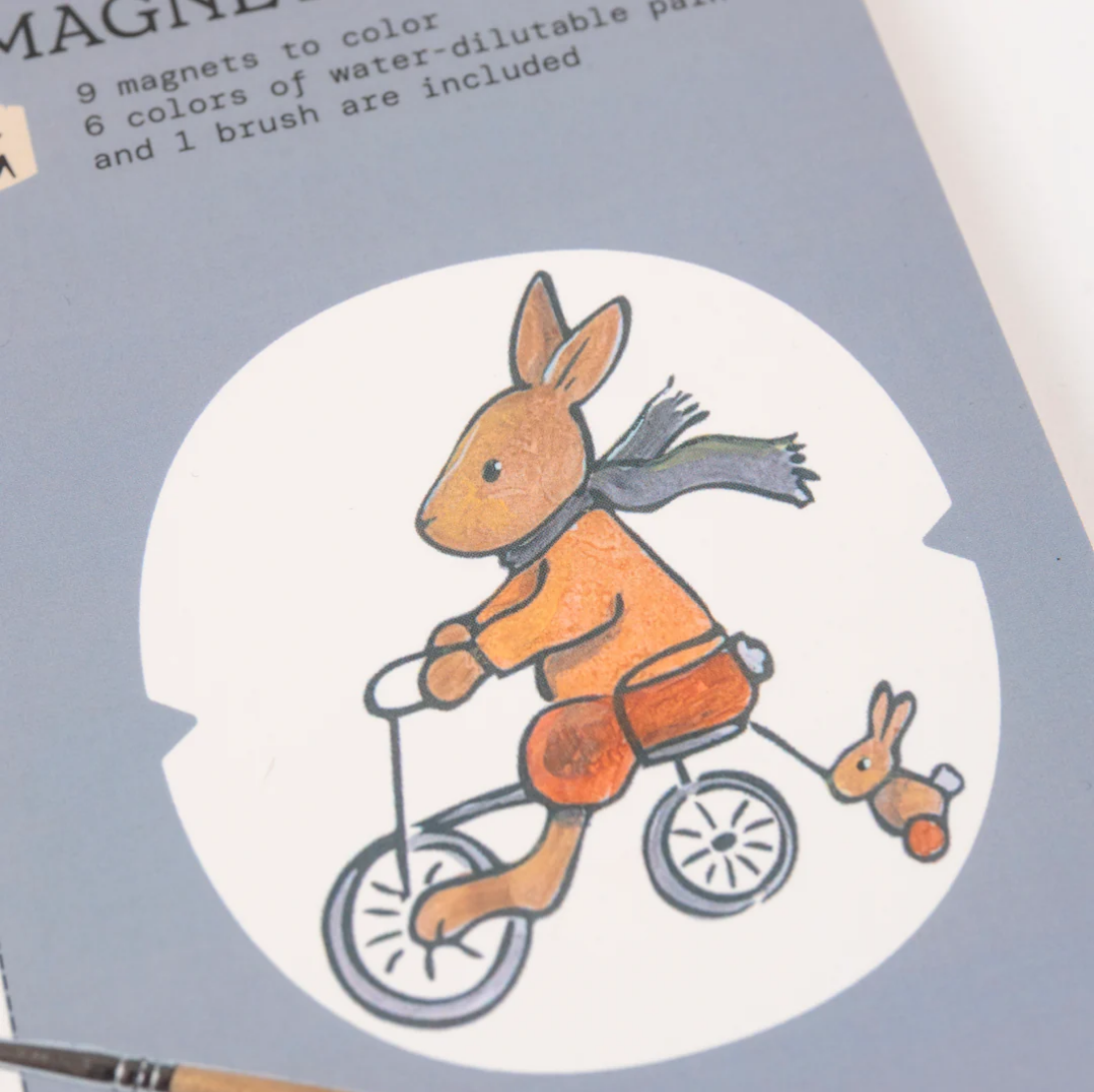 Illustration of a rabbit on a tricycle with a smaller rabbit following, on a product packaging.