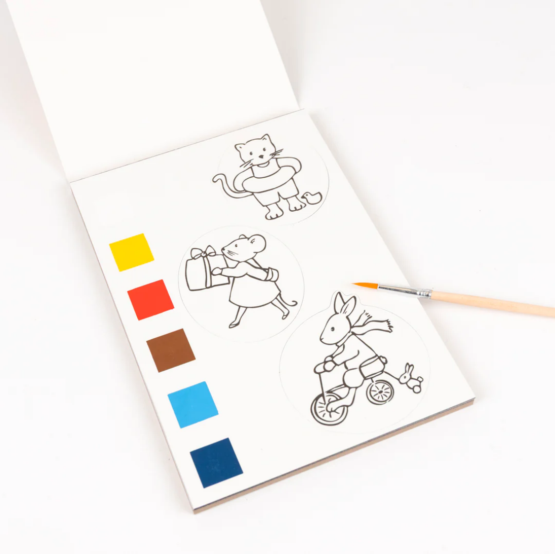 Coloring book with illustrations of a cat, a girl, and a rabbit on a tricycle, accompanied by color swatches and a paintbrush.