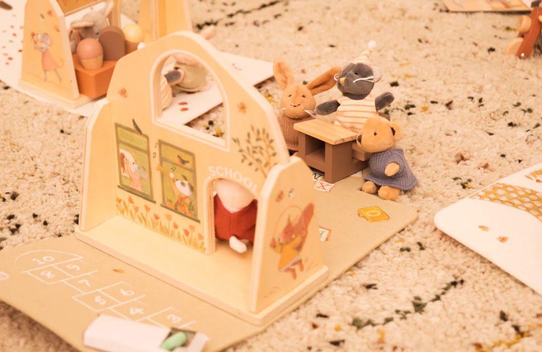 Small wooden toy set with animals on a textured surface