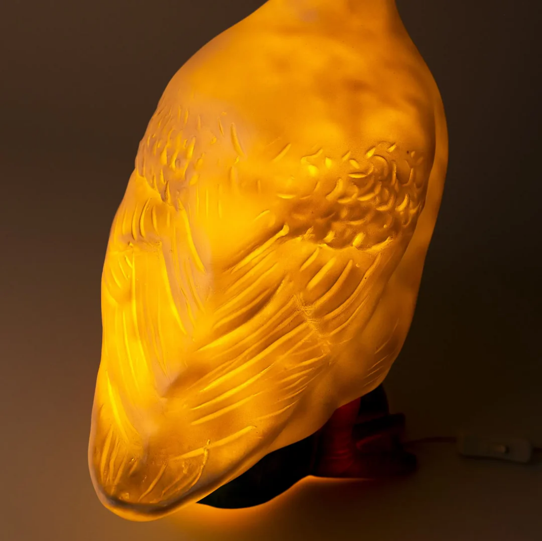 goose lamp  in profile with a warm glow on a dark background
