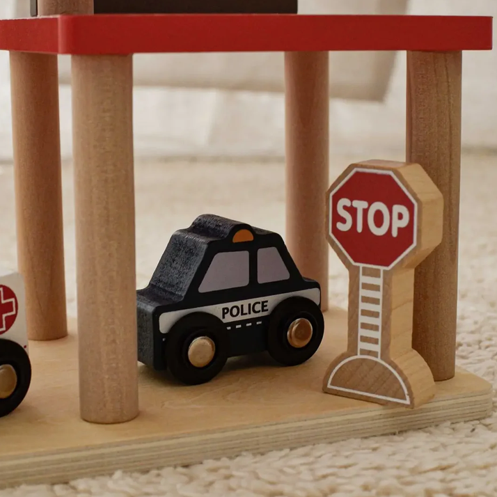 Wooden toy police car and stop sign on a wooden stand with a white background