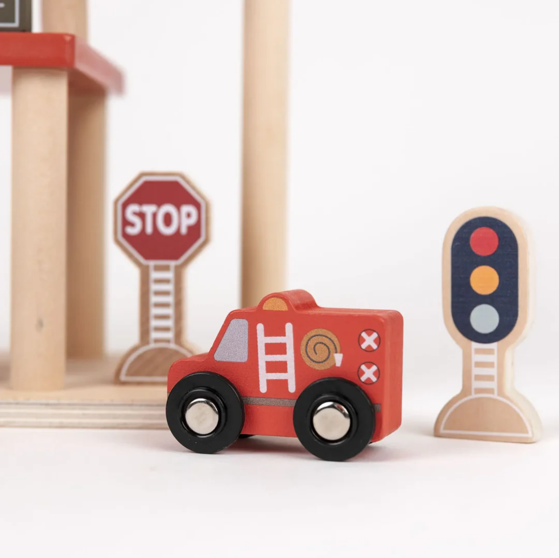 Wooden toy fire truck with stop sign and traffic light on a white background