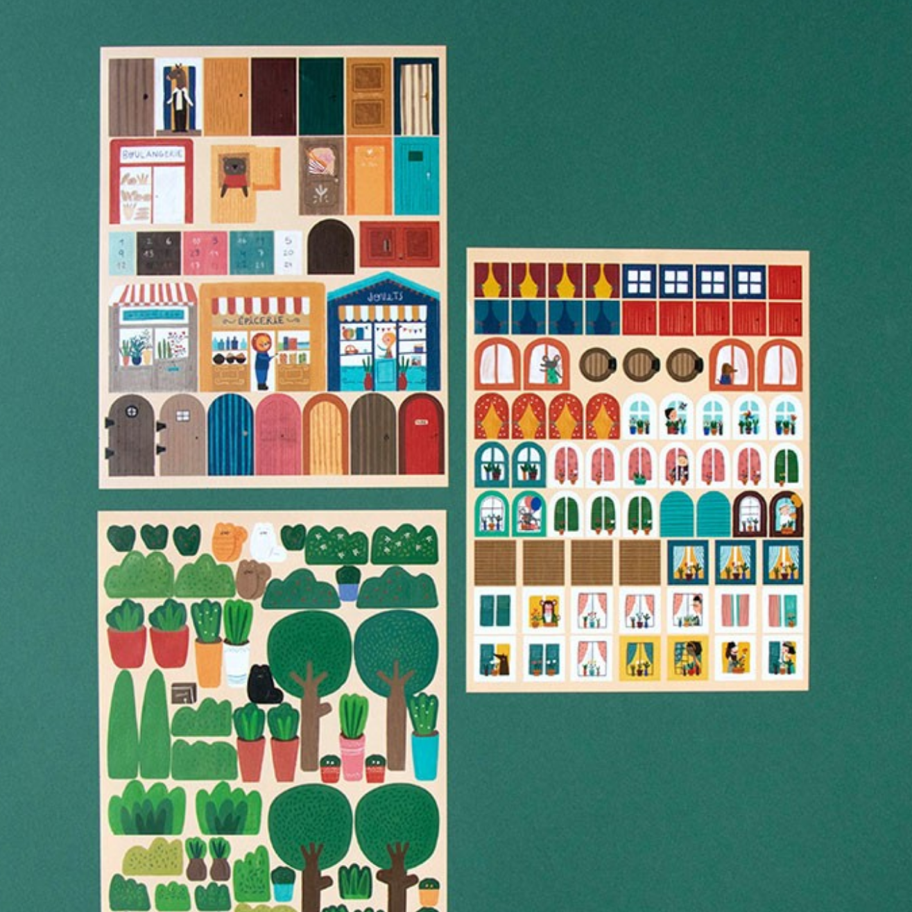 Set of illustrated building and tree stickers on a green background