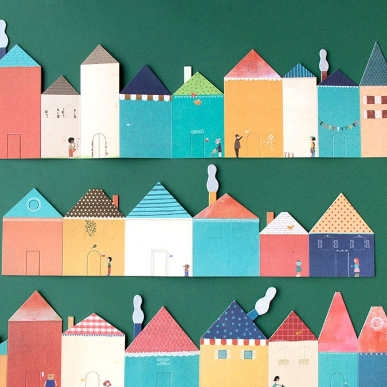 Colorful paper house models on a green background