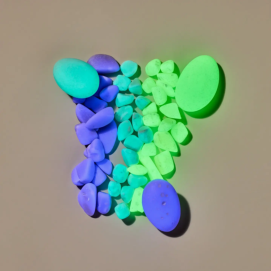 Colorful pebbles in blue, green, and purple on a beige background