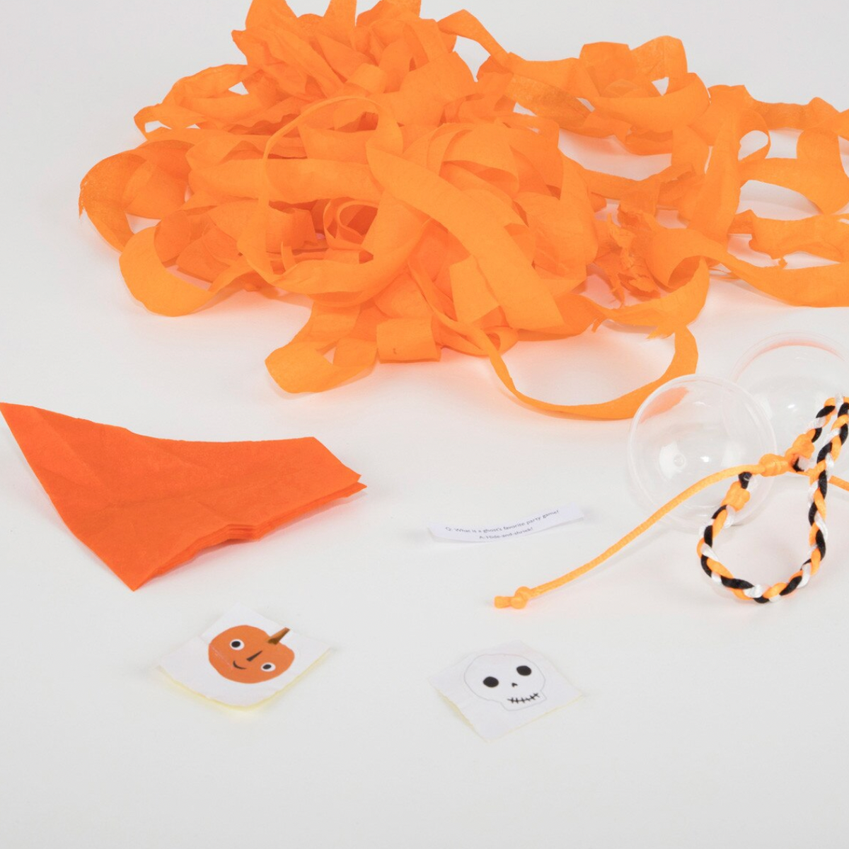 Halloween party decoration kit containing orange paper streamers, an orange fabric triangle, clear plastic balloons, and small pumpkin and ghost stickers on a white background.