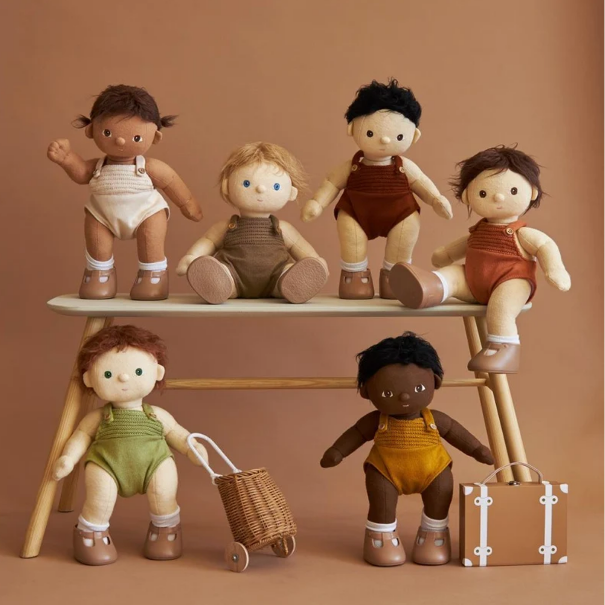 Set of dolls with different outfits and accessories on a brown background