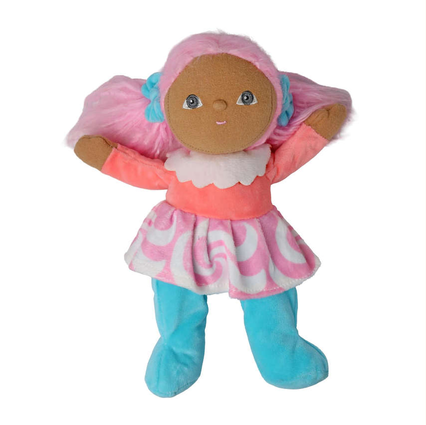 A soft plush doll with a brown face, pink hair, a pink and white patterned dress, and turquoise-blue legs, shown against a plain white background.