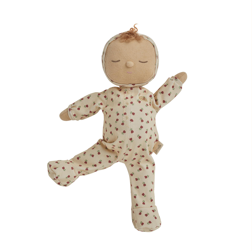 A handmade fabric doll with a stitched face, closed eyes, and brown hair, wearing a cream-colored footed onesie with a small brown floral pattern, set against a plain white background.