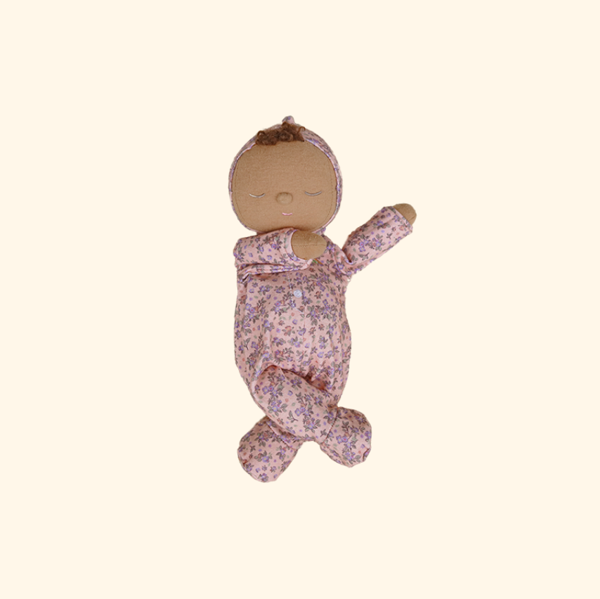 Baby doll in a floral outfit on a white background