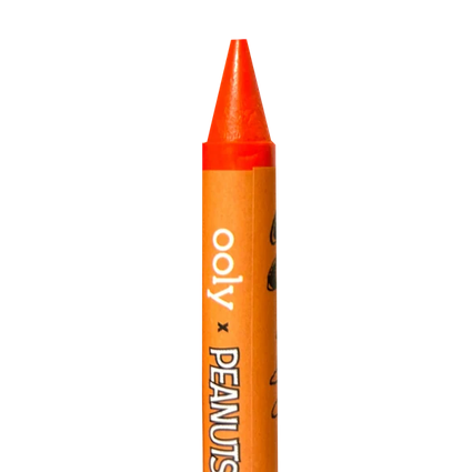 An orange crayon with a pointed tip, featuring a label that reads 'ooly x PEANUTS' in white text, isolated on a white background.