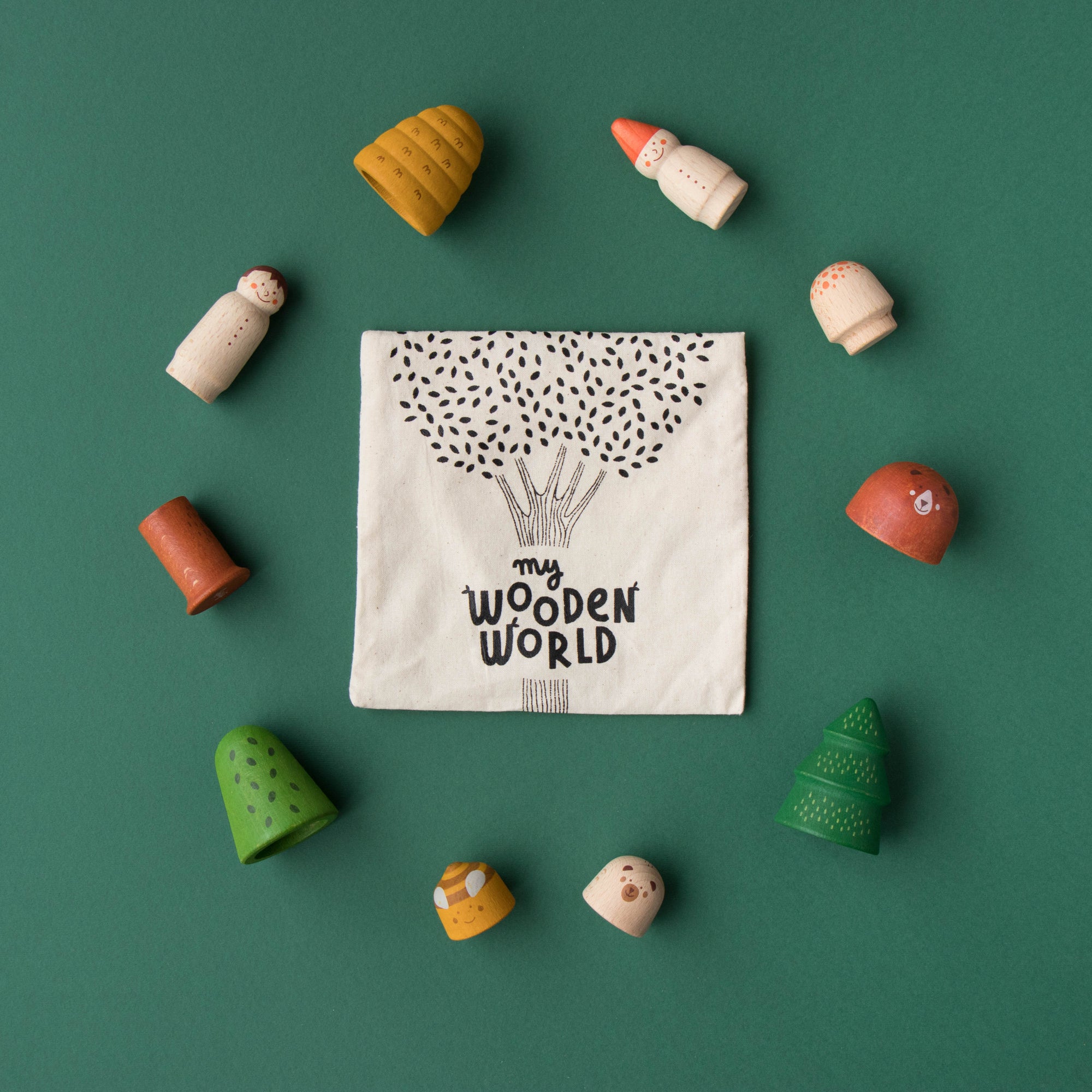 Wooden toys arranged around a fabric square with 'my wooden world' text on a green background