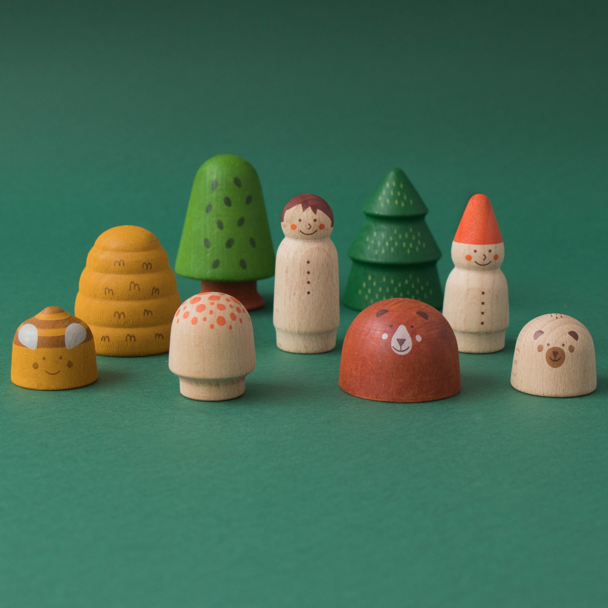 Set of colorful wooden toy figures on a green background