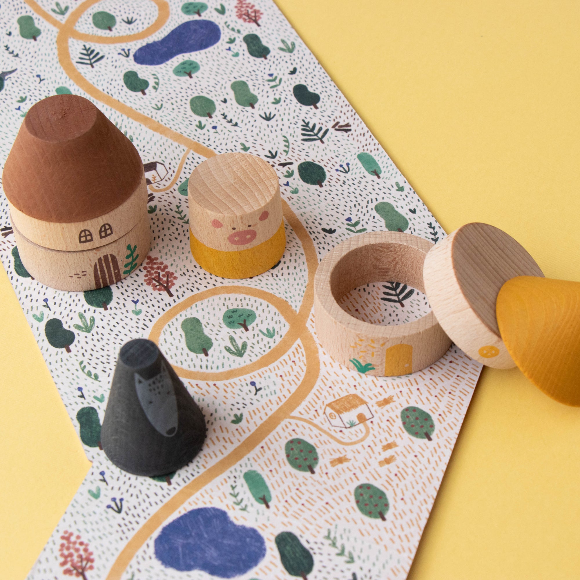 Wooden toys on a colorful play mat with a yellow background