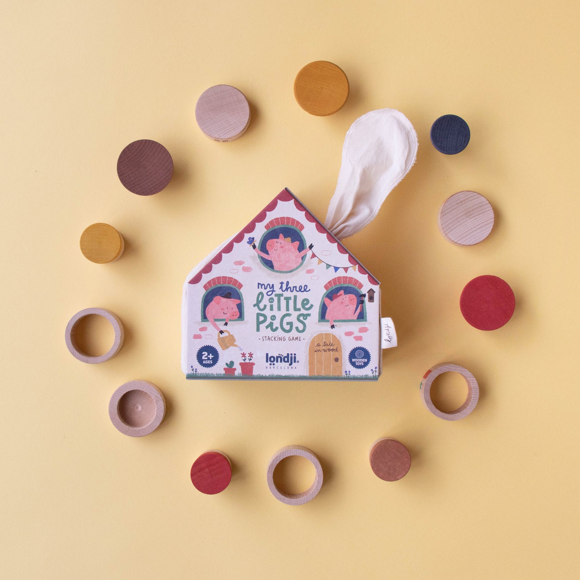 Children's toy packaging with wooden rings on a yellow background