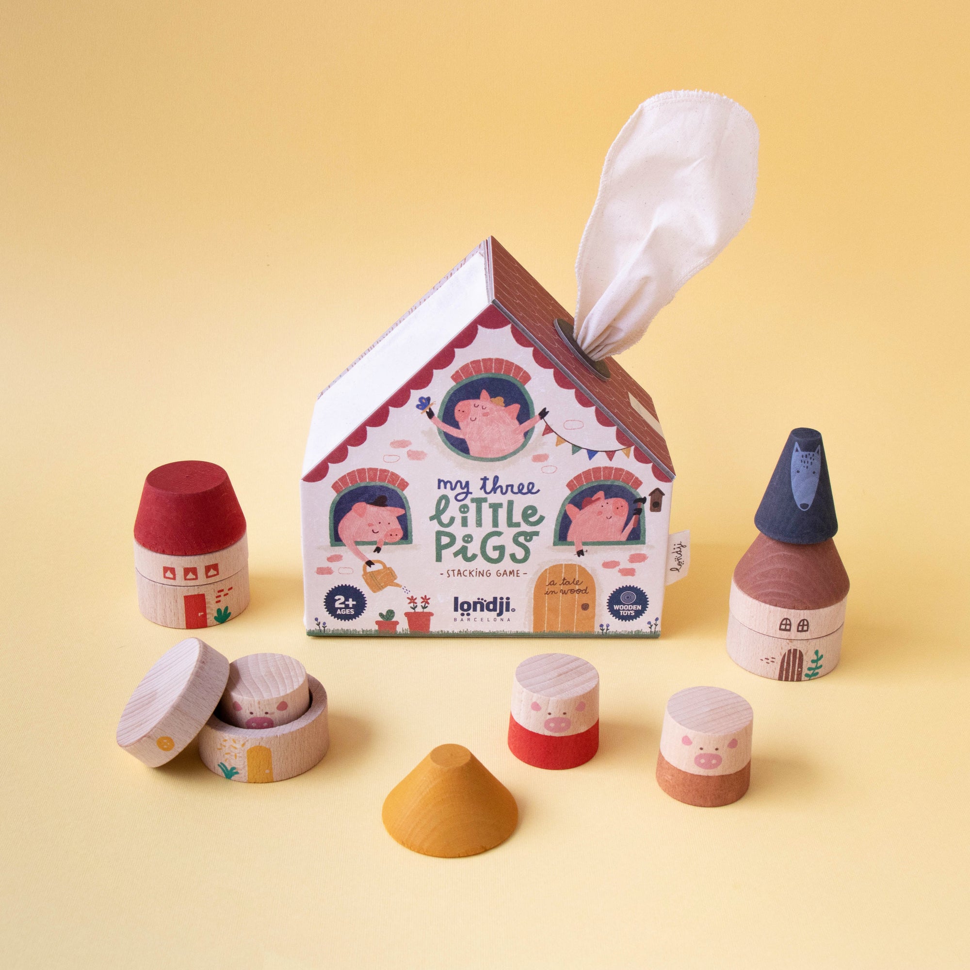 Wooden toy set with a house-shaped tissue box on a yellow background