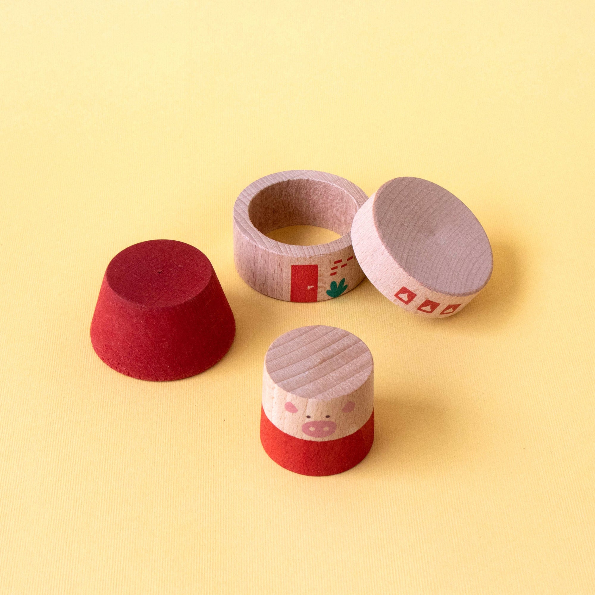 Four small cylindrical containers with different colored lids on a yellow background