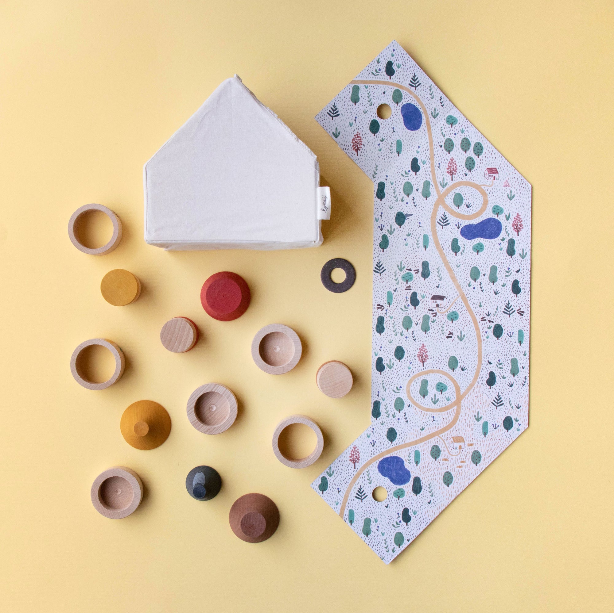 Colorful wooden toys and a house-shaped box on a yellow background