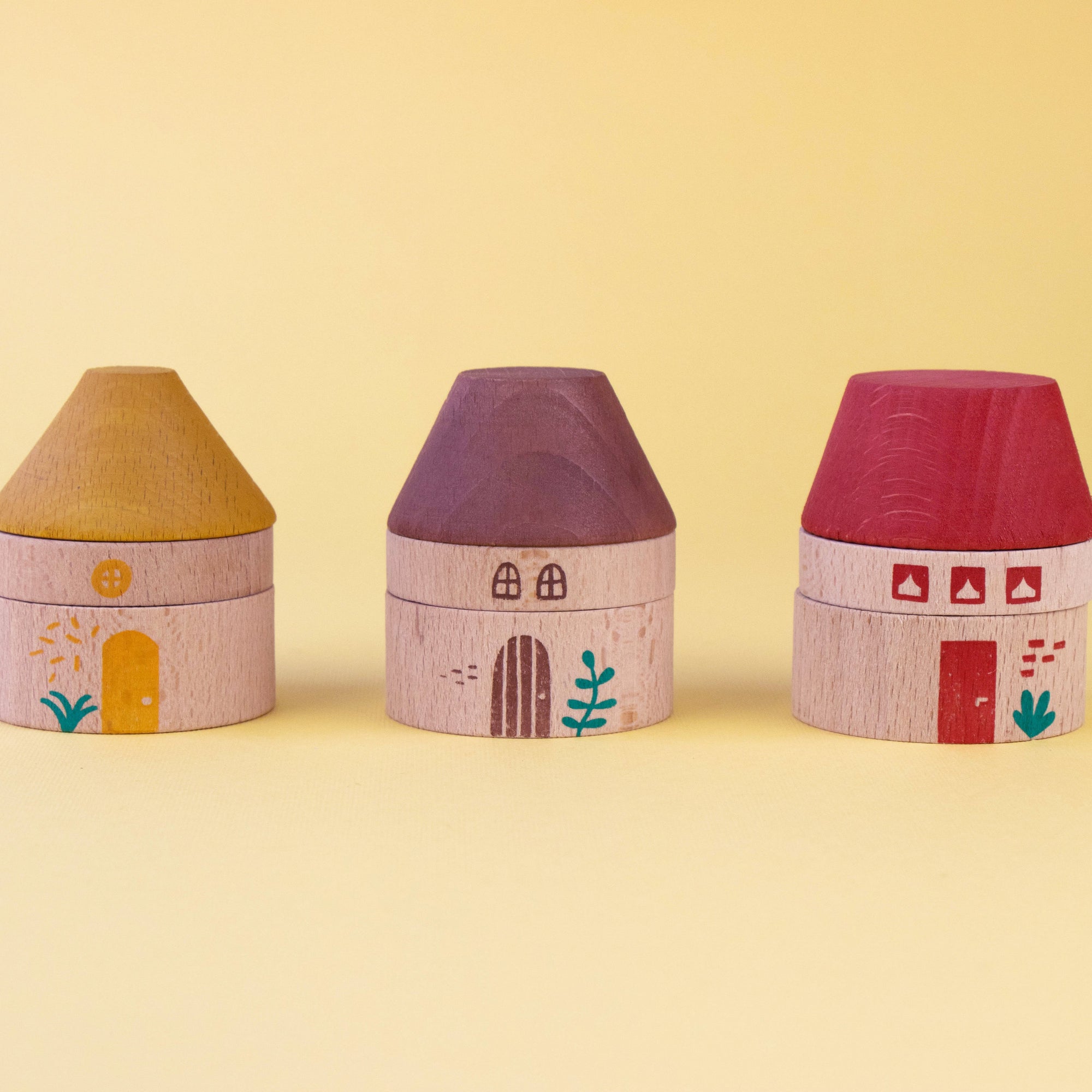 Three colorful house-shaped boxes on a yellow background