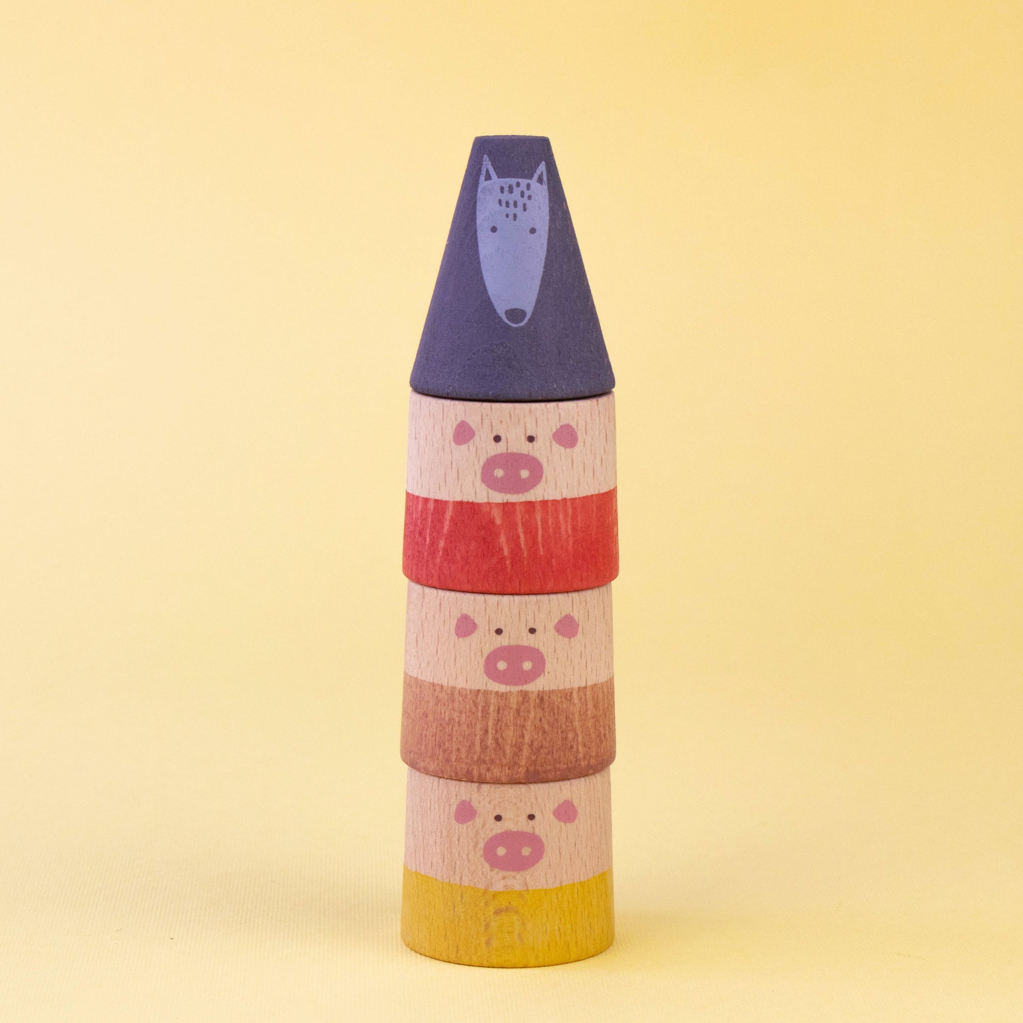 Stack of colorful cylindrical toys with animal faces on a yellow background