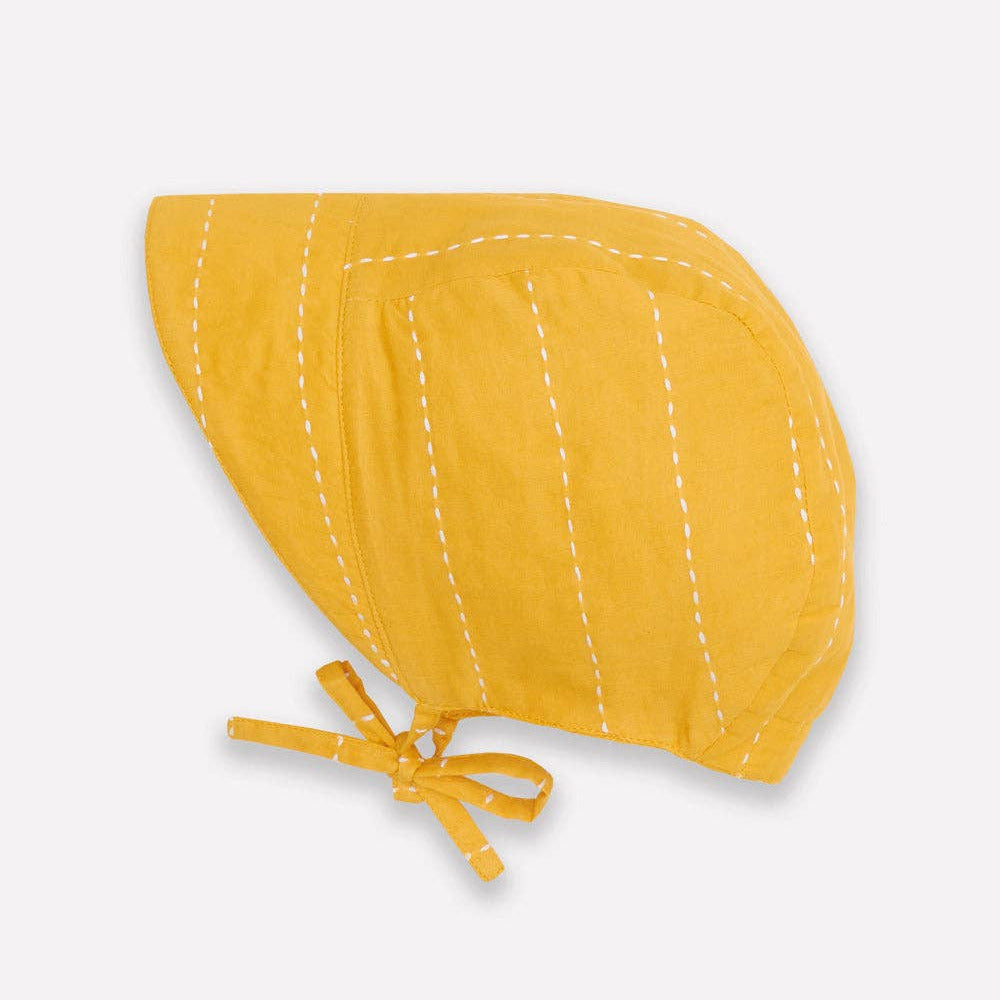 Yellow baby bonnet with a bow on a white background