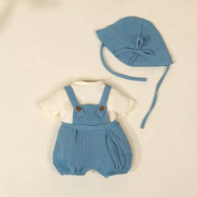 Baby blue romper with matching hat on a beige background