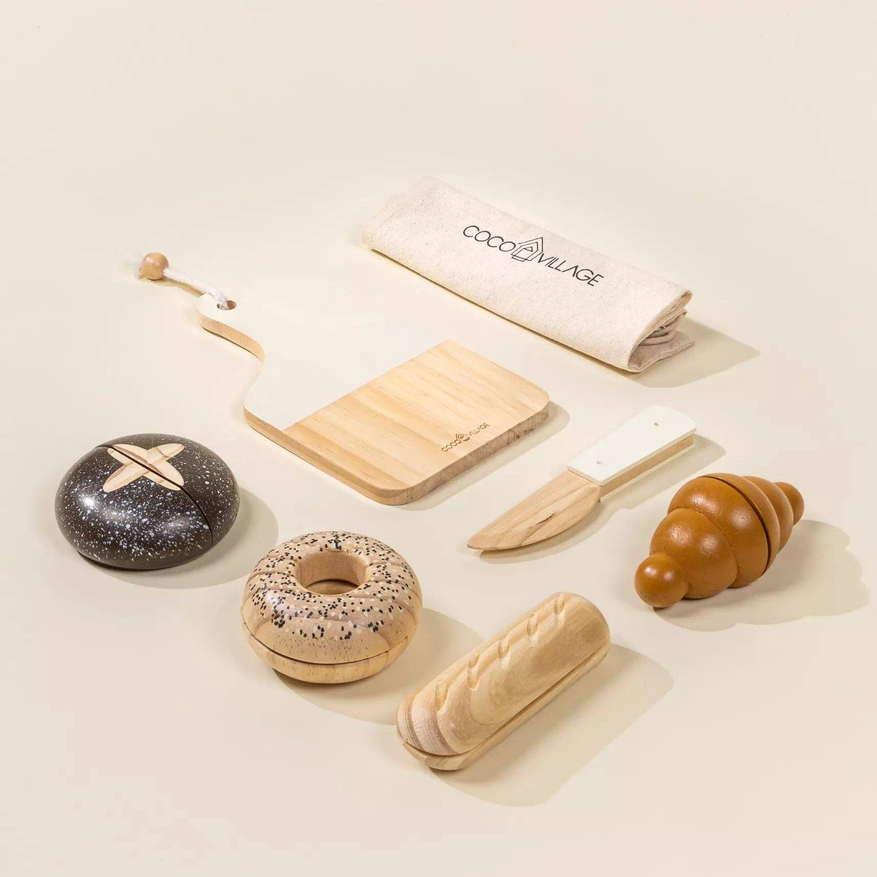 Wooden toys resembling food items on a light surface with a branded napkin.