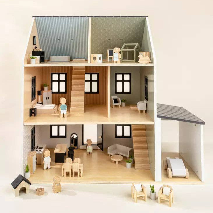 Model of a dollhouse with various rooms and furniture on a white background