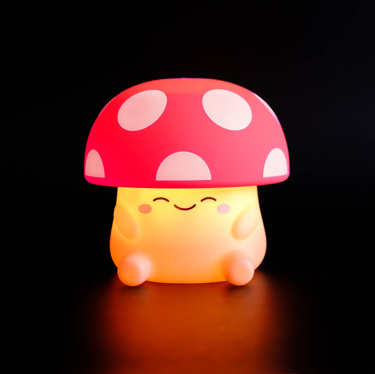 Mushroom-shaped night light with a smiling face on a black background