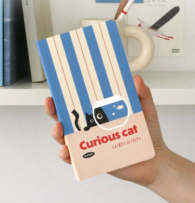 Notebook with blue and beige striped cover featuring a cat illustration held by a hand.