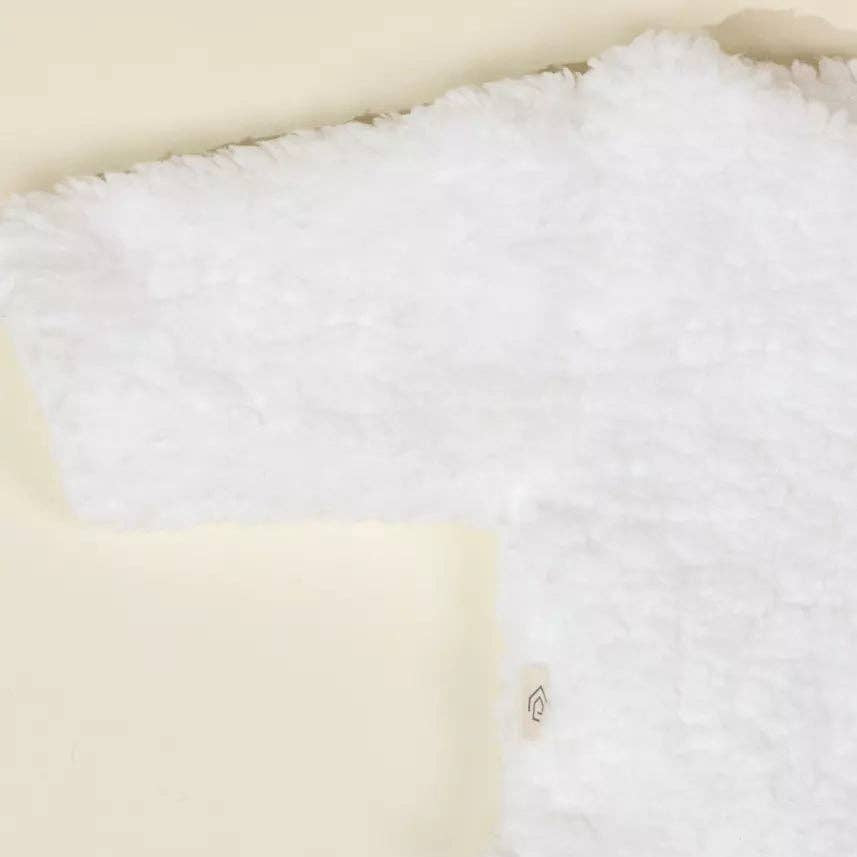 Close-up of a textured fabric with white, beige, and blue sections.
