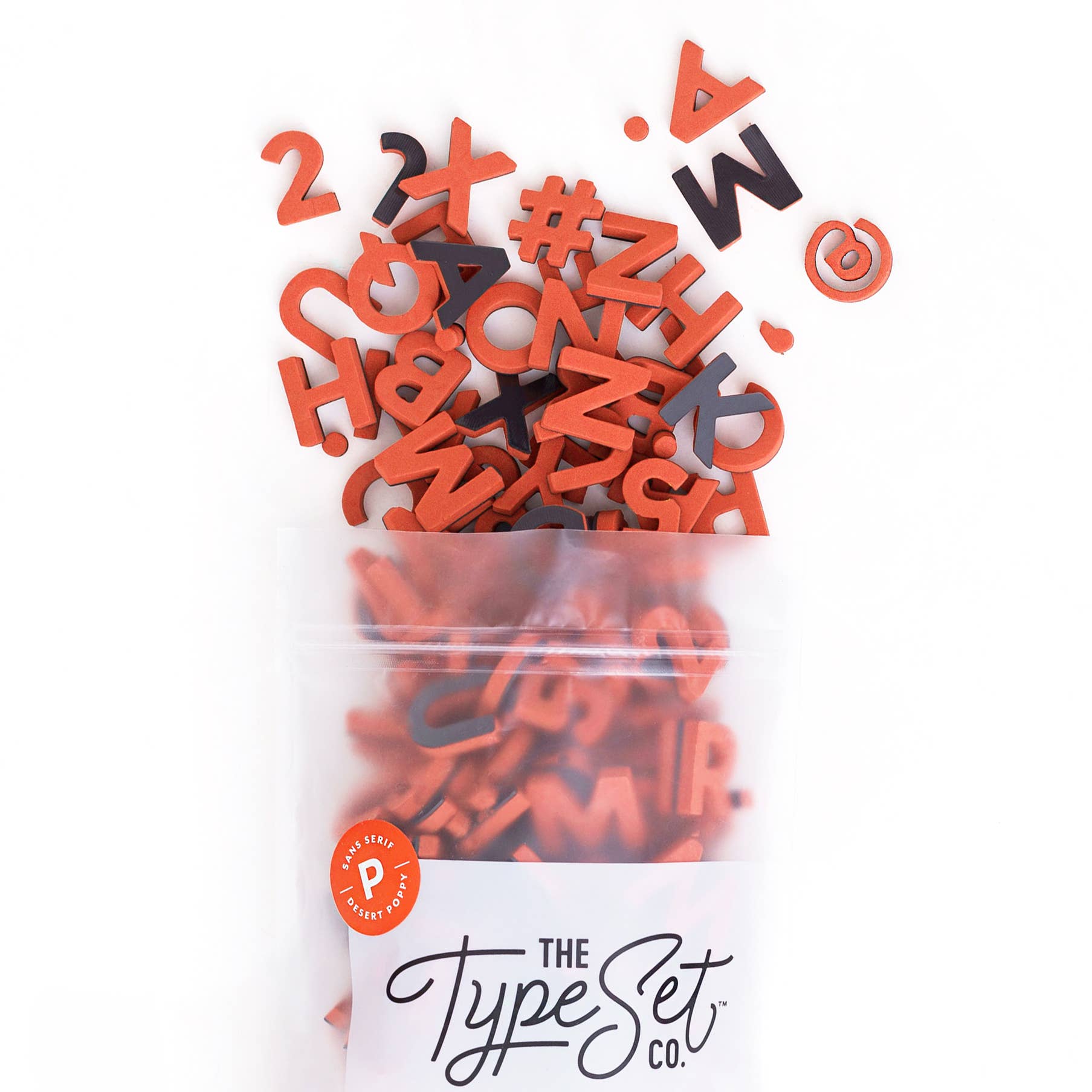 Bag of red and black letter and number magnets from The Type Set Co. on a white background