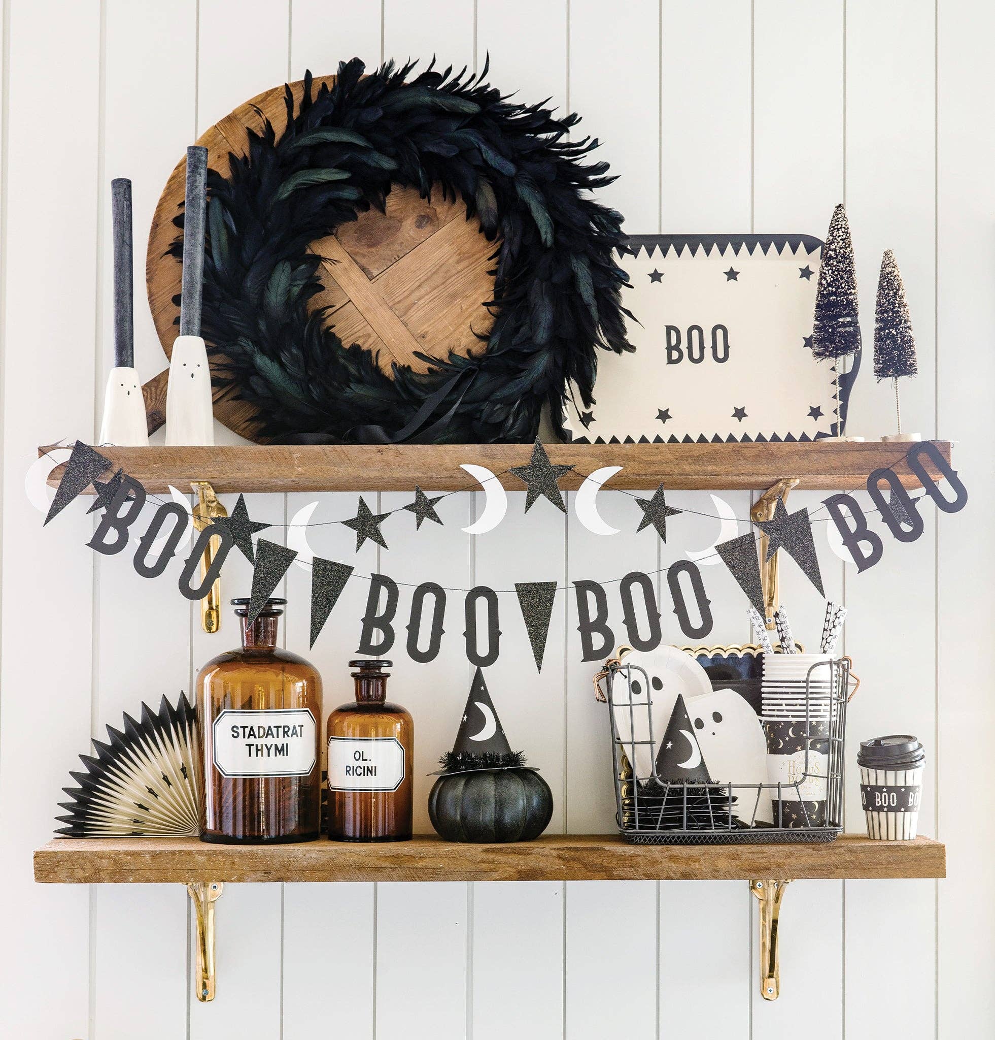 Halloween-themed shelf with decorative items against a white wooden wall.