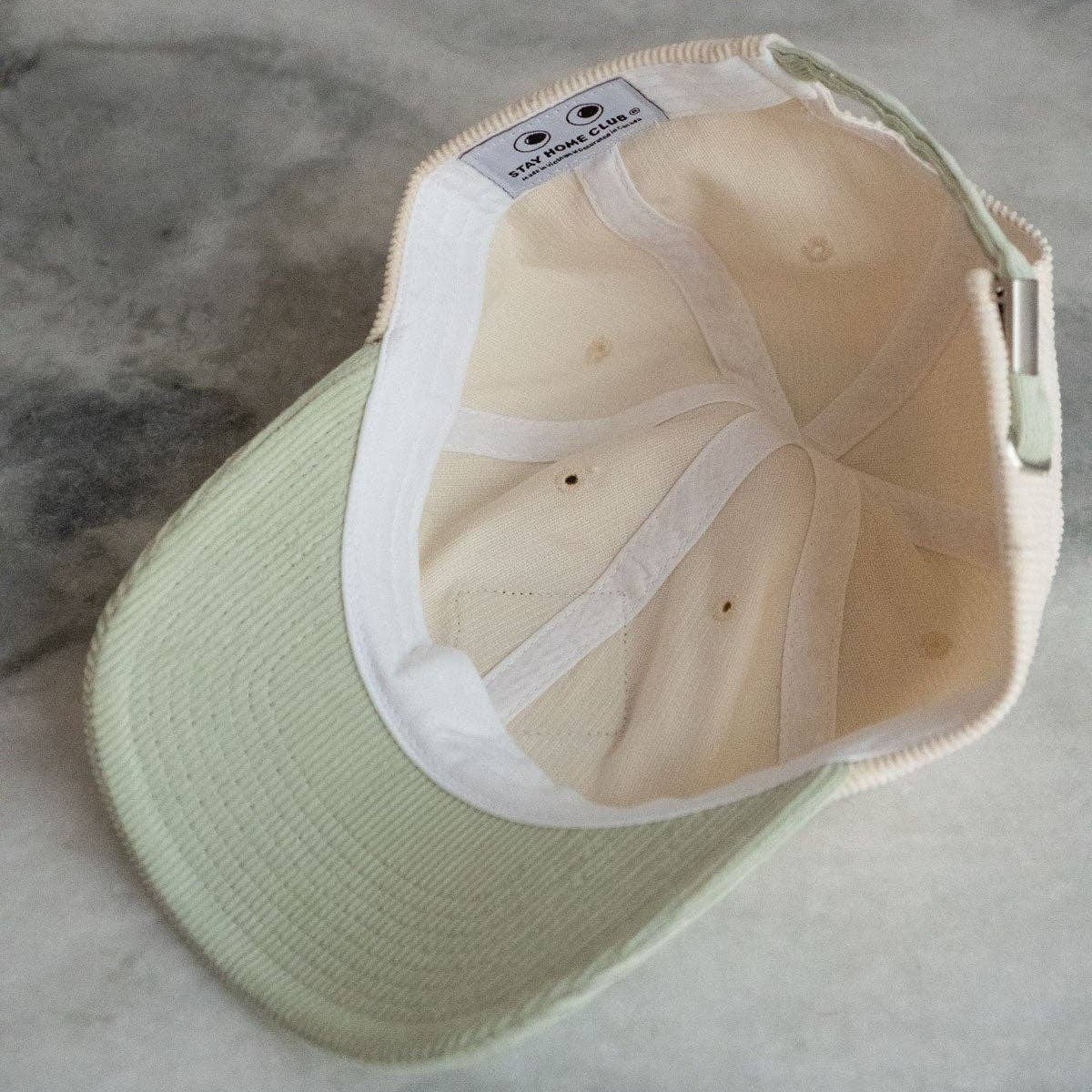 Light green cap with white interior on a gray surface