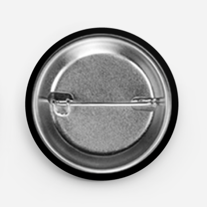Round metal button badge with a pin on a white background