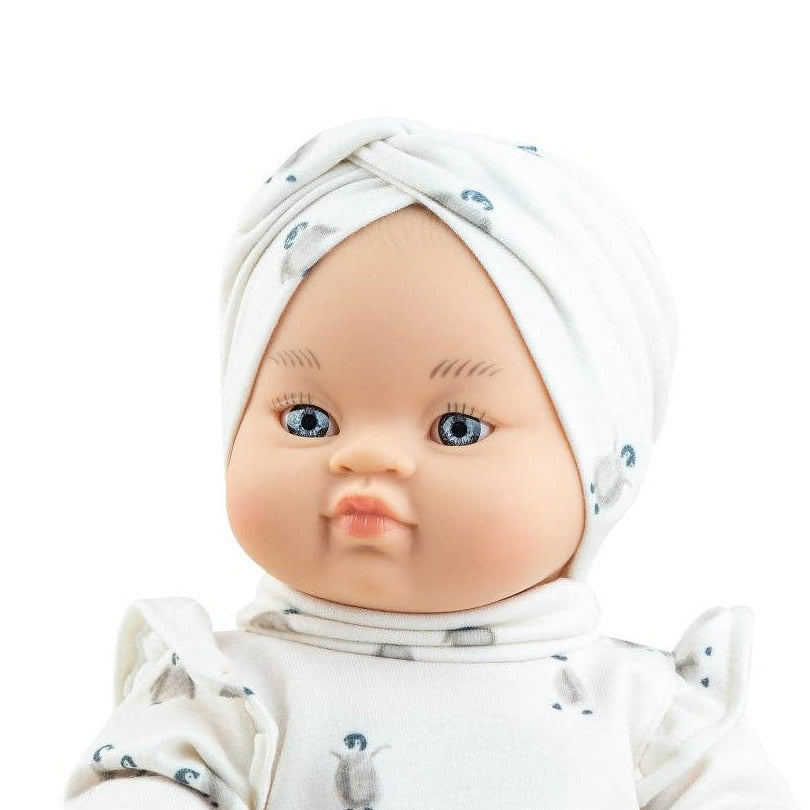 Baby doll wearing a white outfit with a green skirt on a white background