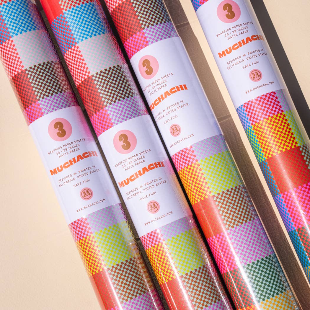 Three rolls of colorful paper with 'MUCHACHI' branding on a beige background