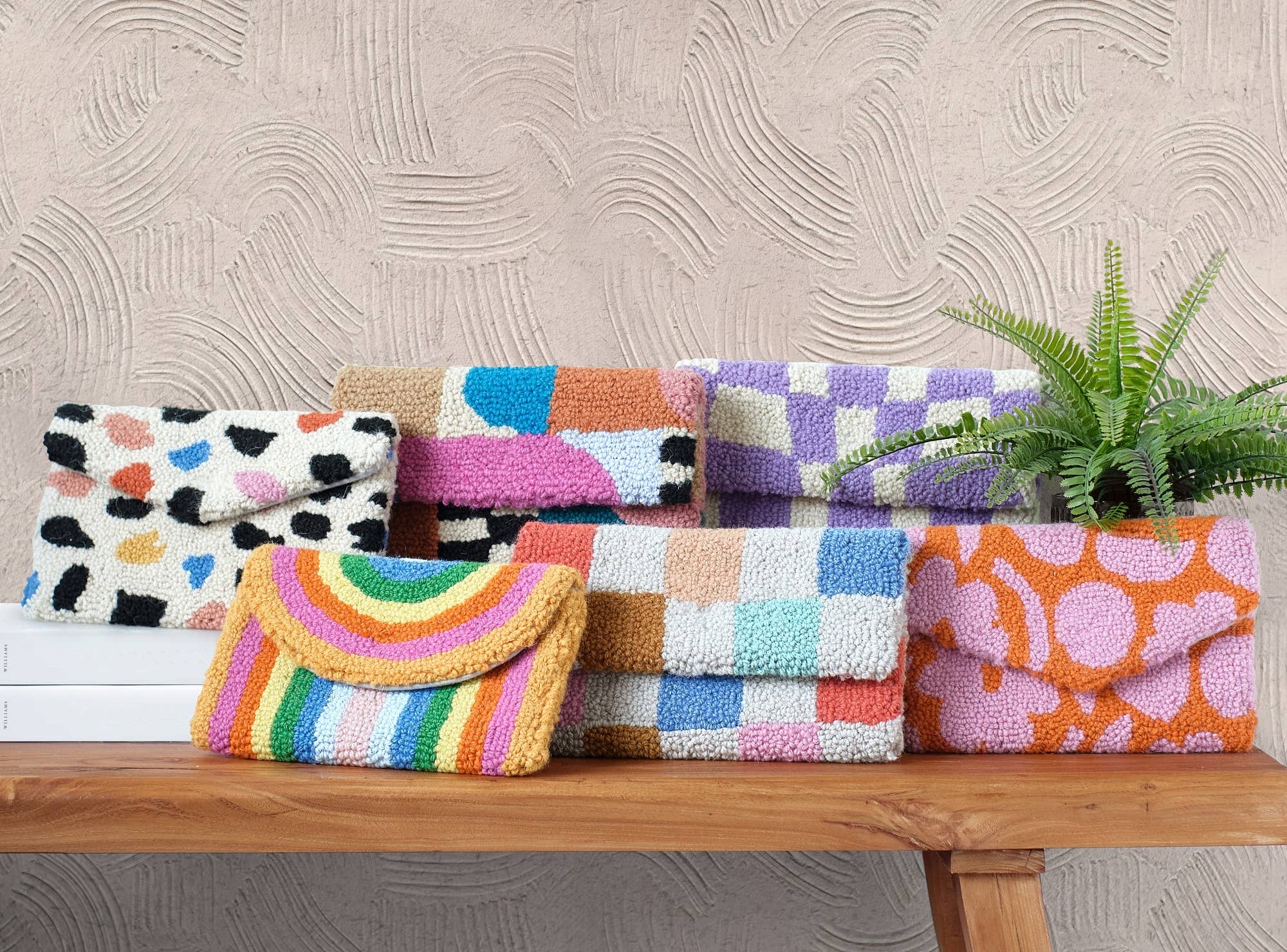 Colorful handbags on a wooden surface with a textured wall background