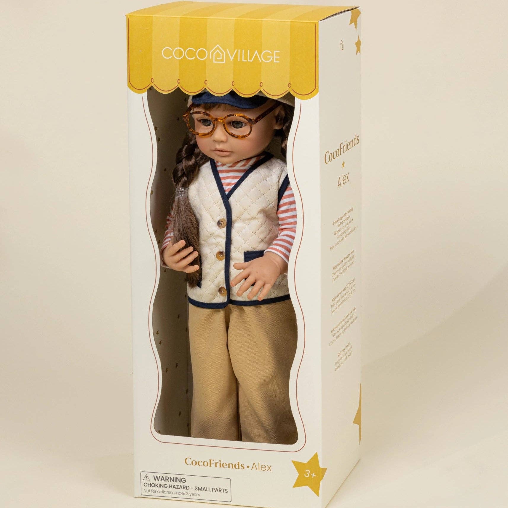 Doll in a box with a yellow roof and visible branding on a beige background