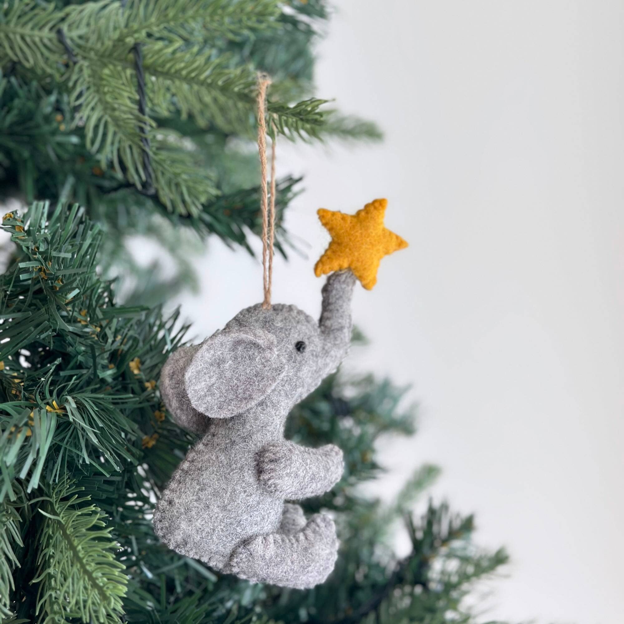 Decorative elephant ornament with a star on a Christmas tree