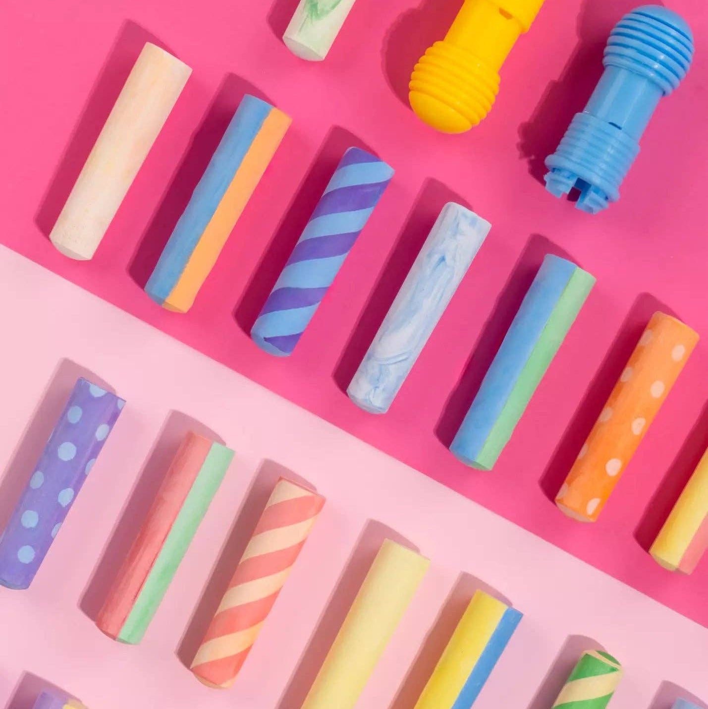 Colorful crayon-like objects on a pink background